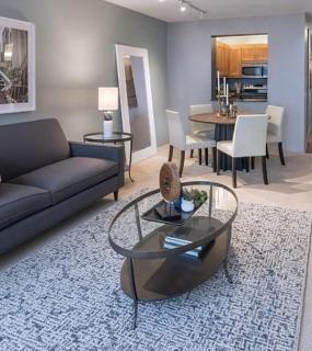 Spacious living room with a dining area, modern furniture, and soft lighting at Columbus Plaza