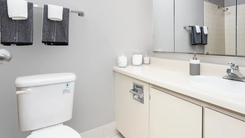 A clean and functional bathroom with a vanity sink, toilet, mirrored medicine cabinet, and shower