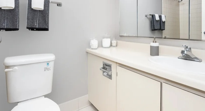 A clean and functional bathroom with a vanity sink, toilet, mirrored medicine cabinet, and shower