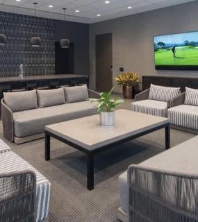 Stylish resident lounge with comfortable seating, a large TV, and a kitchenette at Columbus Plaza