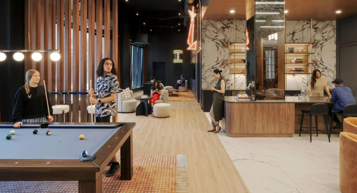 Lively amenity lounge at Coppia apartments in Chicago with a pool table, modern bar, and comfortable seating