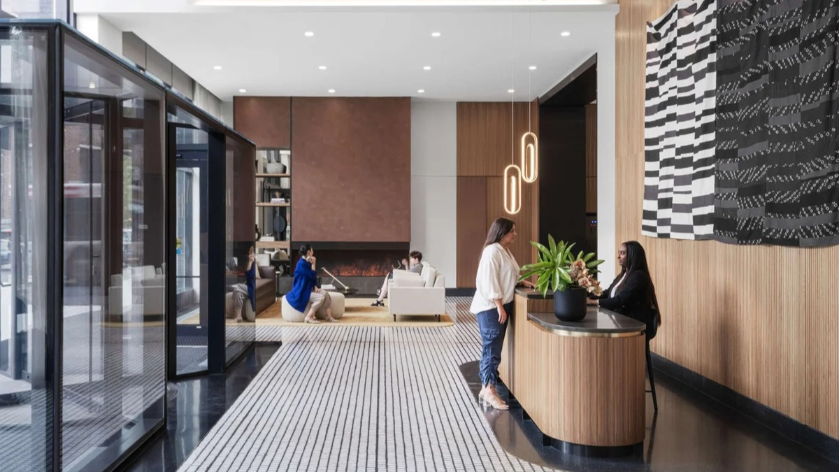 Elegant and modern lobby reception area at Coppia apartments in Chicago, with stylish wood accents and seating