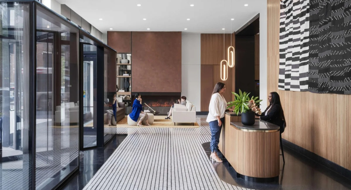 Elegant and modern lobby reception area at Coppia apartments in Chicago, with stylish wood accents and seating