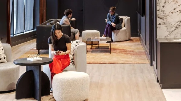 Modern resident lounge at Coppia in Chicago, featuring a "BAR" sign, stylish seating, and a casual atmosphere