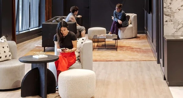 Modern resident lounge at Coppia in Chicago, featuring a "BAR" sign, stylish seating, and a casual atmosphere