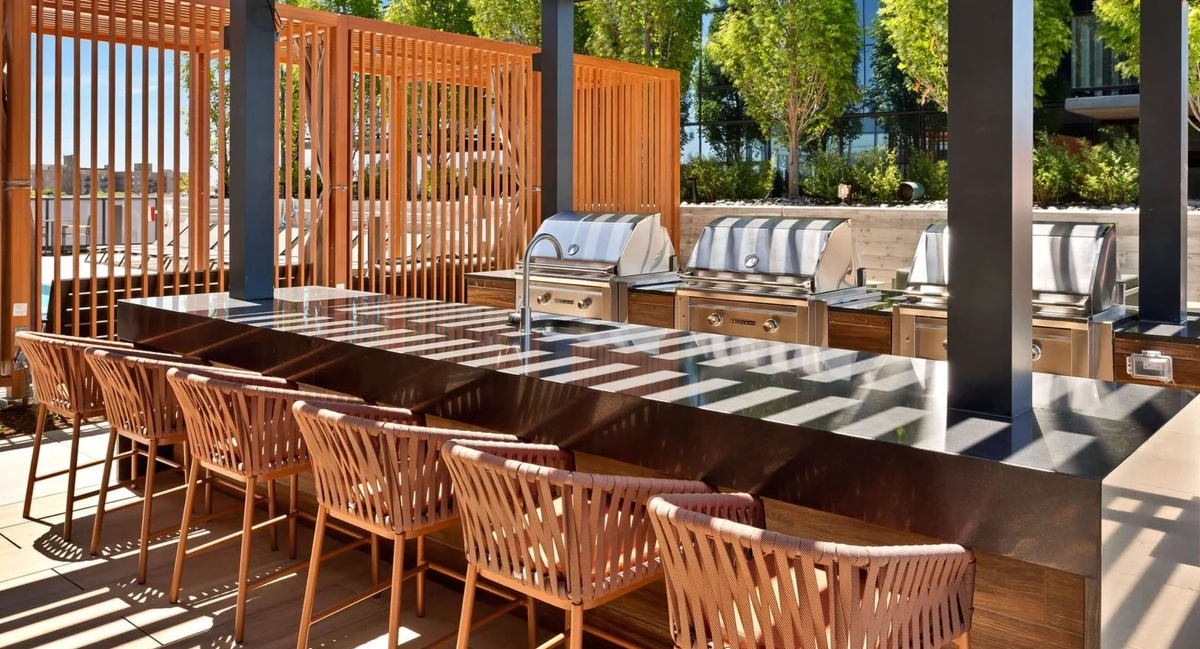 Outdoor rooftop grilling stations and dining area at Coppia apartments in Chicago, perfect for entertaining