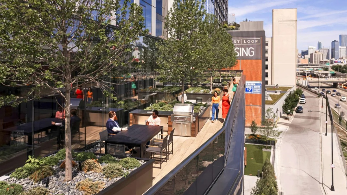 Expansive rooftop terrace at Coppia apartments in Chicago with outdoor seating, green spaces, and city views