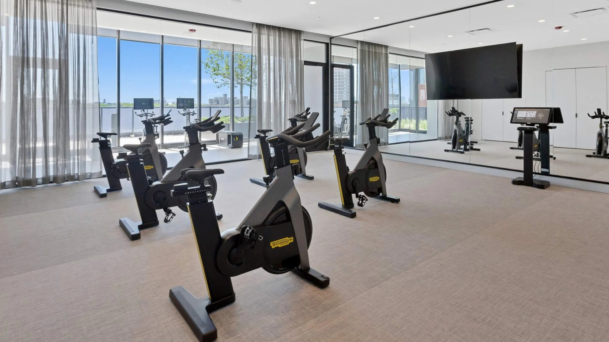 Dedicated spin studio and fitness room at Coppia apartments in Chicago, featuring multiple exercise bikes