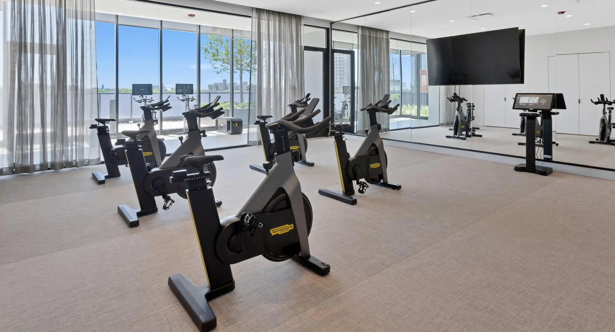 Dedicated spin studio and fitness room at Coppia apartments in Chicago, featuring multiple exercise bikes