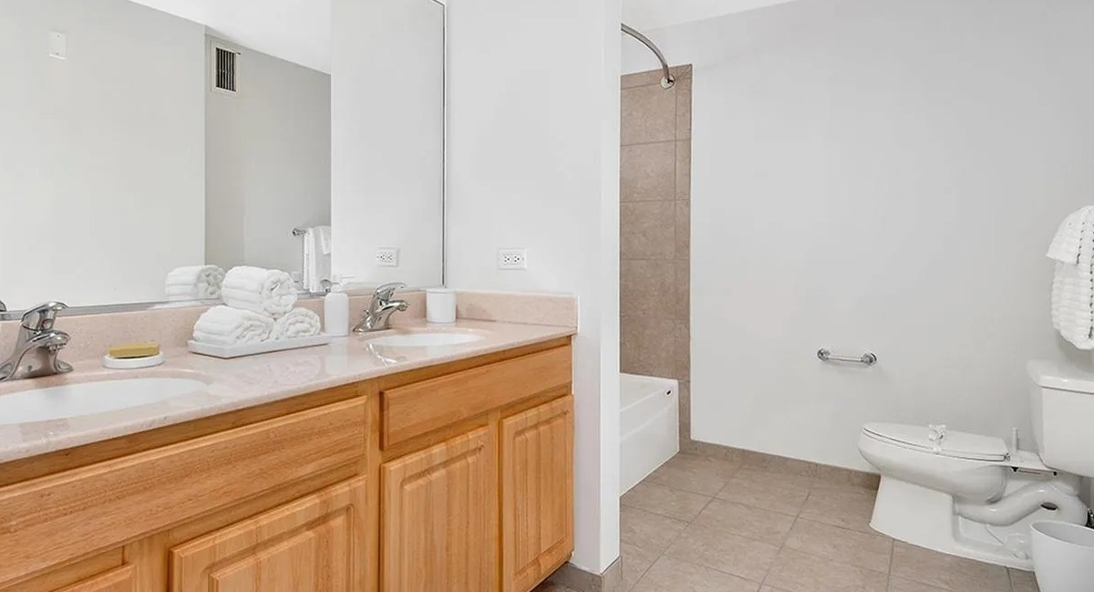 Spacious bathroom with a double vanity, ample counter space, and a shower-tub combination at Echelon at K Station in Chicago