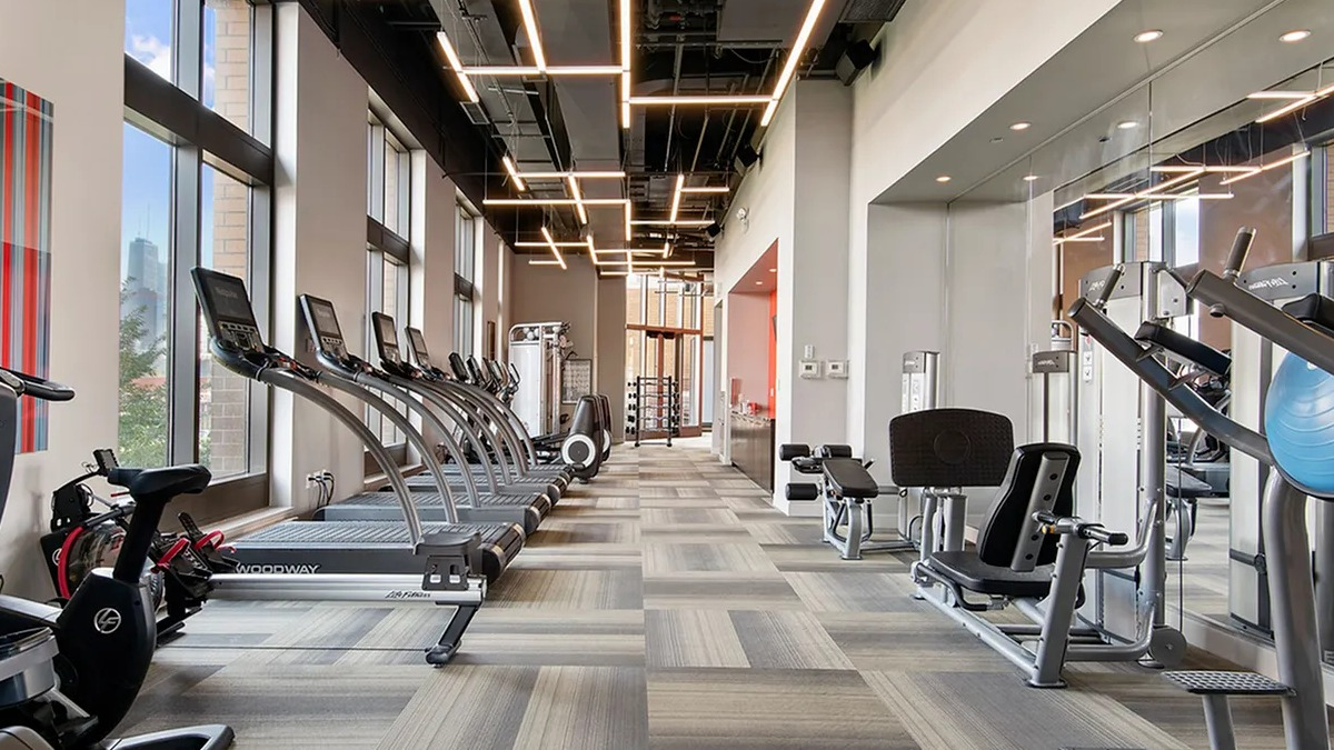 State-of-the-art fitness center with a wide array of cardio equipment and large windows at Echelon at K Station in Chicago