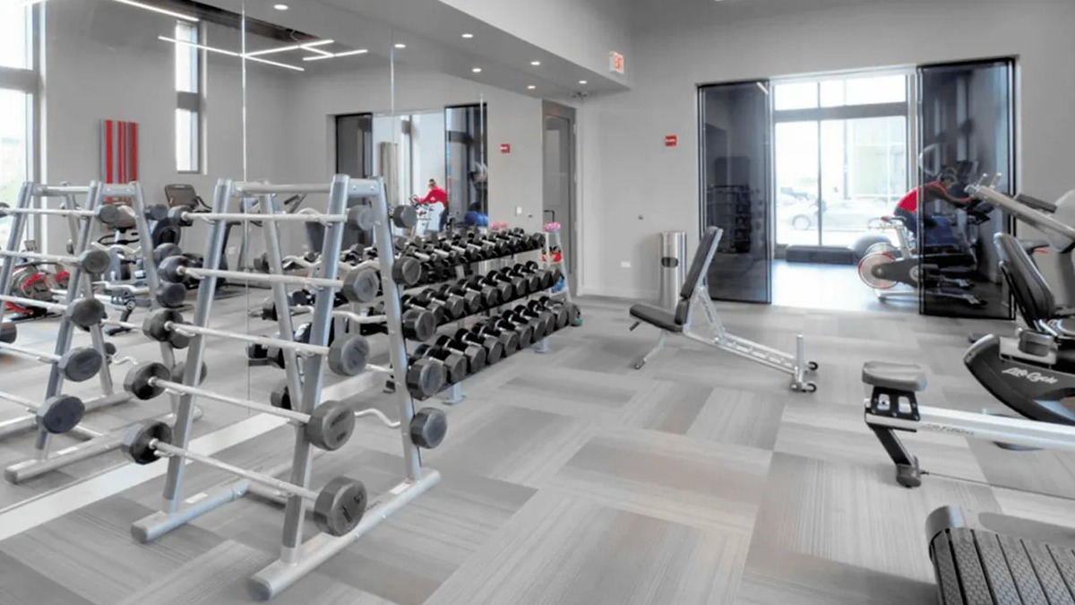 Comprehensive gym area with racks of free weights, benches, and strength training equipment at Echelon at K Station in Chicago