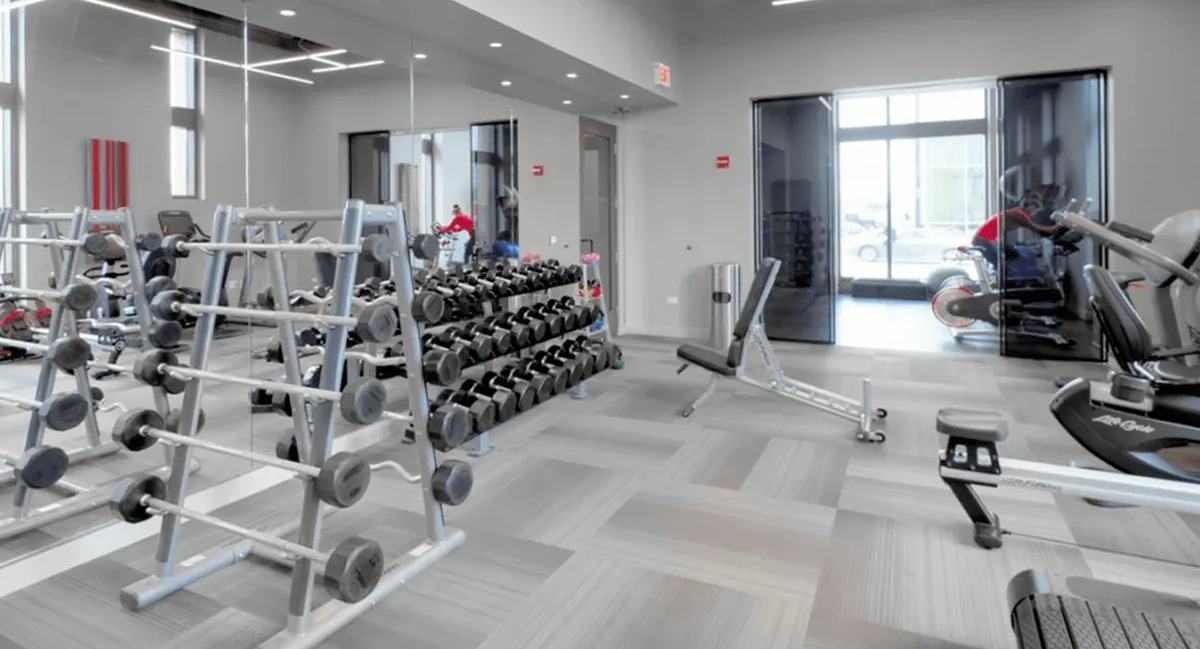 Comprehensive gym area with racks of free weights, benches, and strength training equipment at Echelon at K Station in Chicago