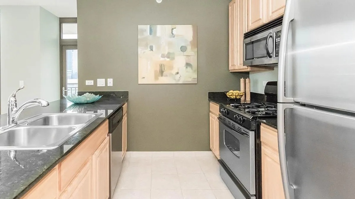 Functional kitchen with light wood cabinets, stainless steel appliances, and ample counter space at Echelon at K Station in Chicago