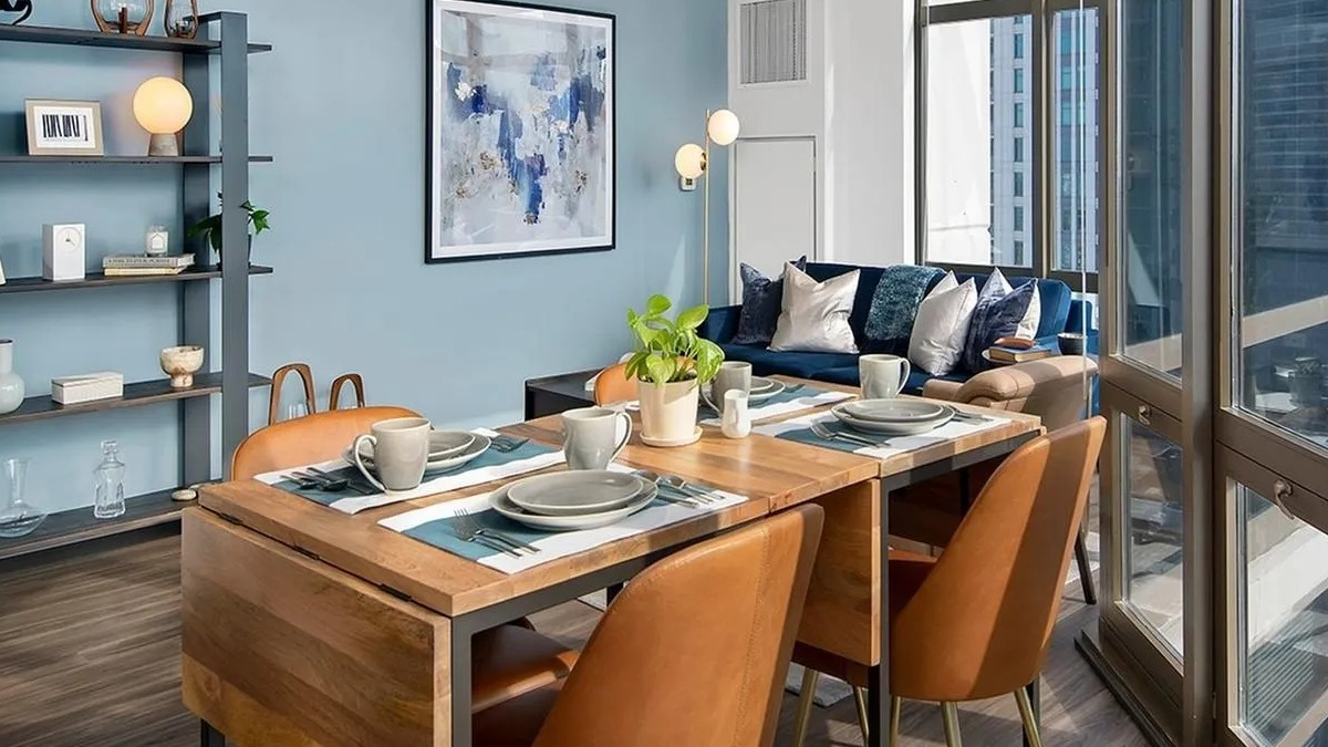 Modern open-concept living and dining area with city views through large windows at Echelon at K Station in Chicago