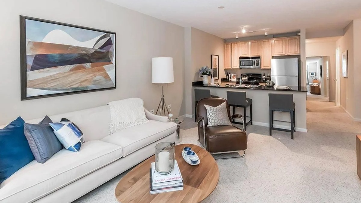 Open-plan living room flowing into a kitchen with a breakfast bar, perfect for modern living at Echelon at K Station in Chicago
