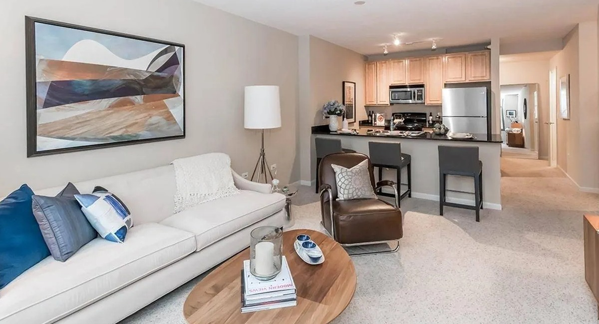 Open-plan living room flowing into a kitchen with a breakfast bar, perfect for modern living at Echelon at K Station in Chicago