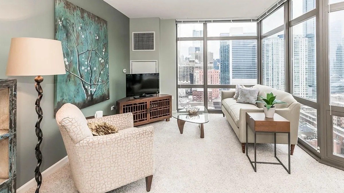 Inviting living room with comfortable seating, modern decor, and expansive windows offering city views at Echelon at K Station in Chicago