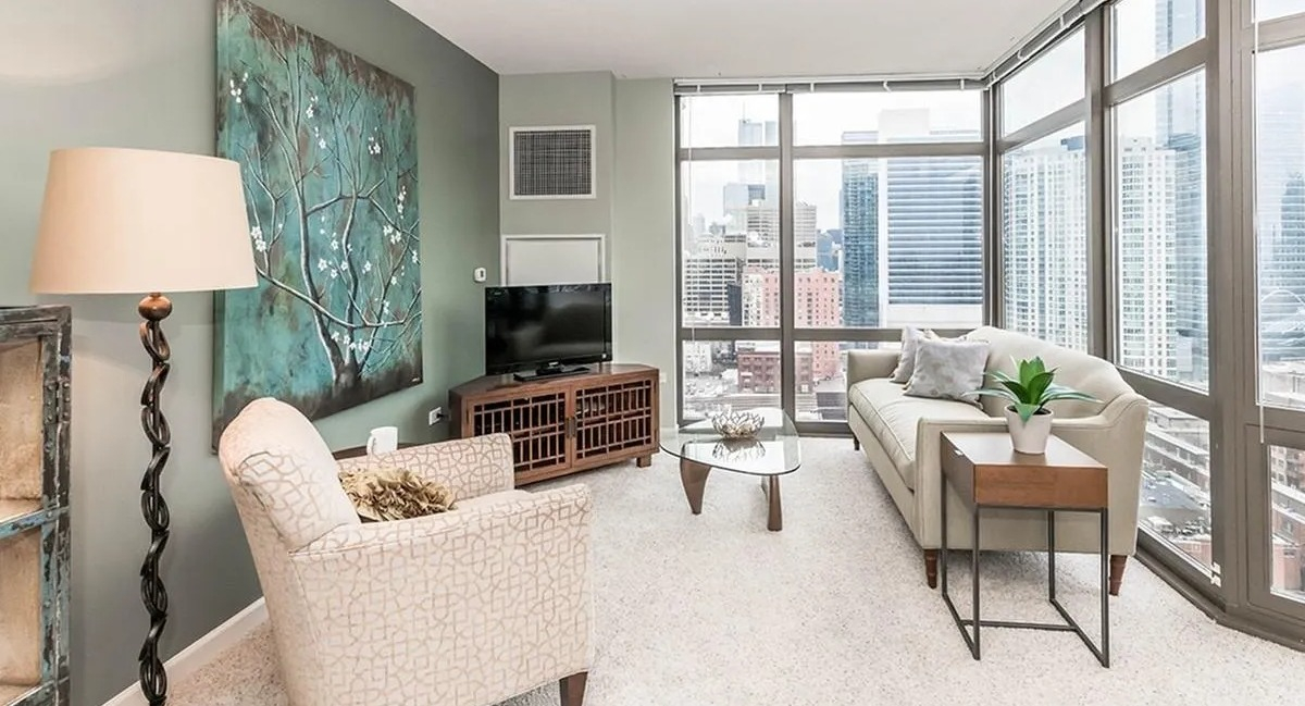 Inviting living room with comfortable seating, modern decor, and expansive windows offering city views at Echelon at K Station in Chicago
