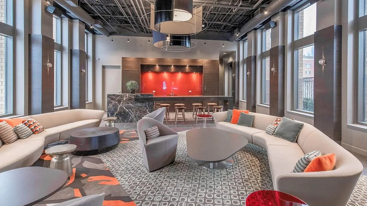 Chic resident lounge with multiple seating arrangements, a stylish bar, and large windows at Echelon at K Station in Chicago