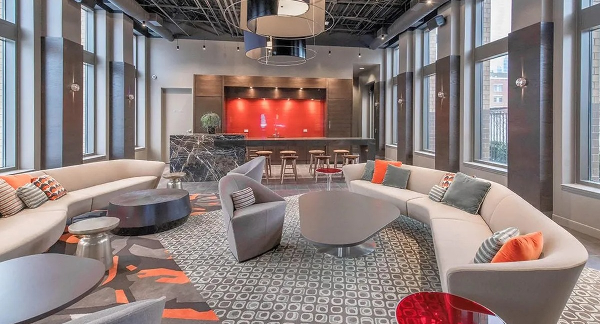 Chic resident lounge with multiple seating arrangements, a stylish bar, and large windows at Echelon at K Station in Chicago