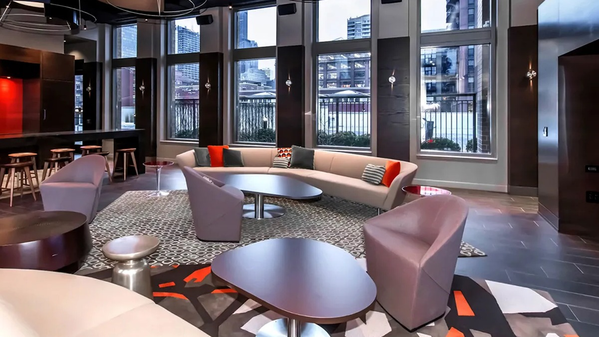 Luxurious resident lounge featuring a bar area, comfortable seating, and a large TV for entertainment at Echelon at K Station in Chicago