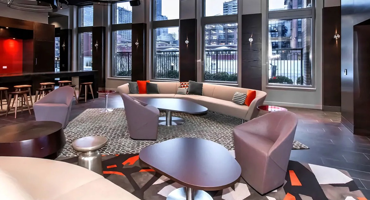 Luxurious resident lounge featuring a bar area, comfortable seating, and a large TV for entertainment at Echelon at K Station in Chicago