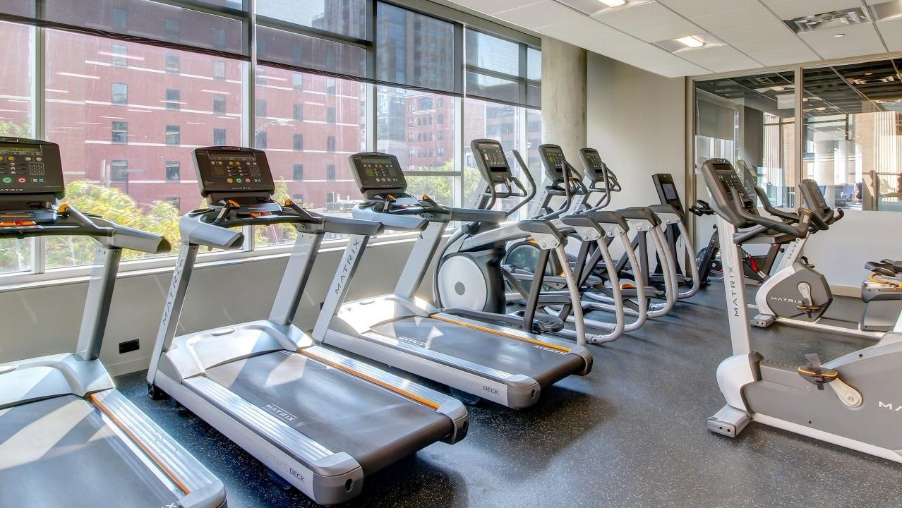 State-of-the-art fitness center with multiple treadmills, ellipticals, and exercise bikes at Eight O Five Apartments in Chicago