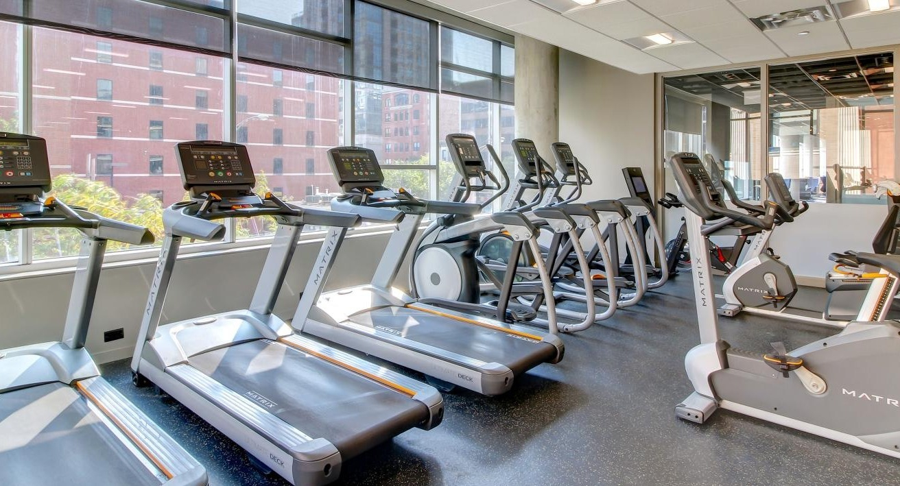 State-of-the-art fitness center with multiple treadmills, ellipticals, and exercise bikes at Eight O Five Apartments in Chicago
