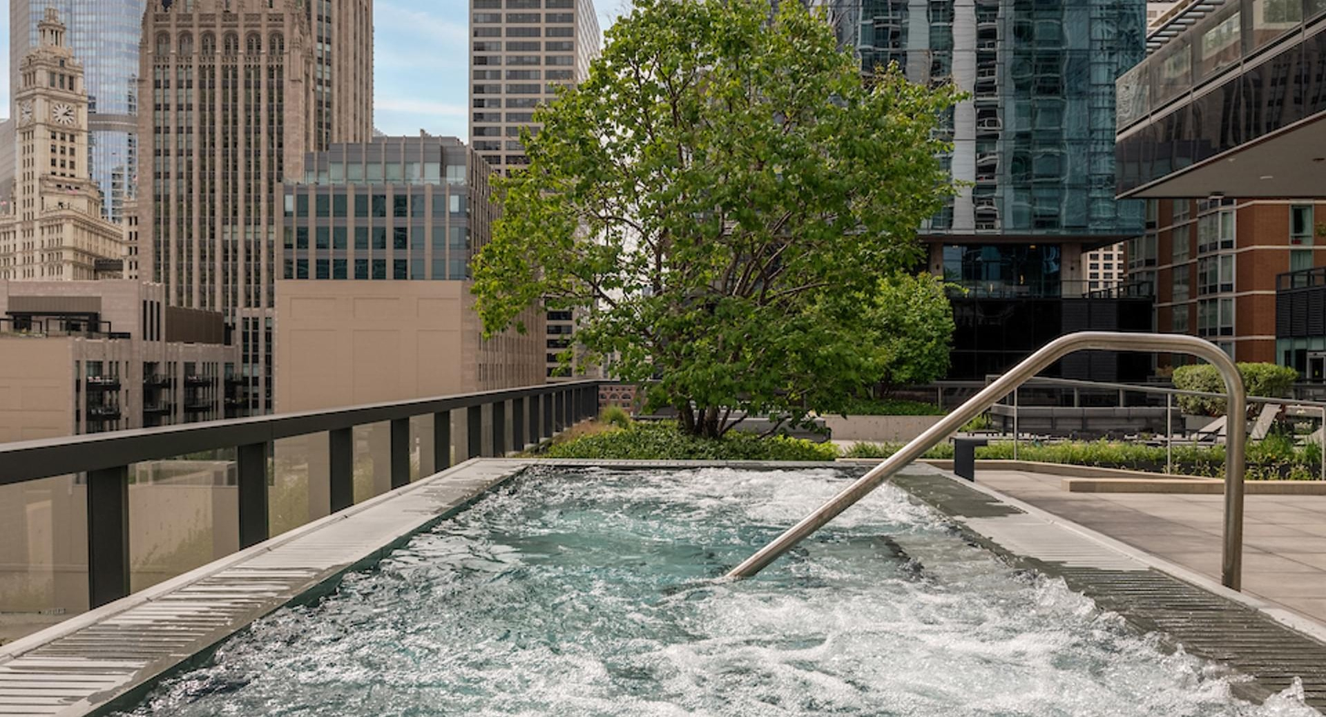 Elevated outdoor hot tub with bubbling water and skyline views, offering a relaxing retreat at Optima Signature apartments in Chicago