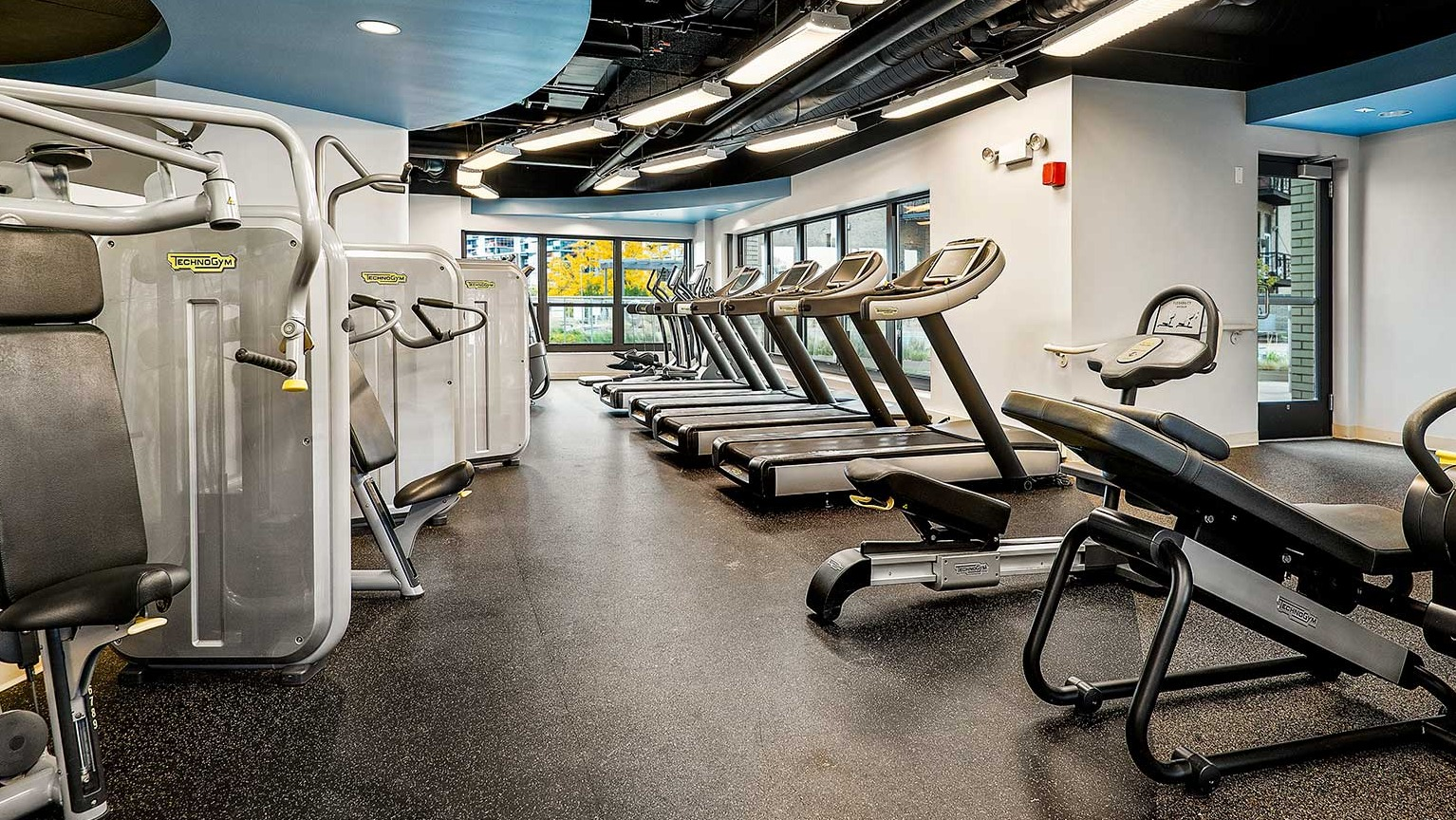 State-of-the-art fitness center with a variety of cardio machines and strength training equipment, at Eleven Thirty apartments in Chicago