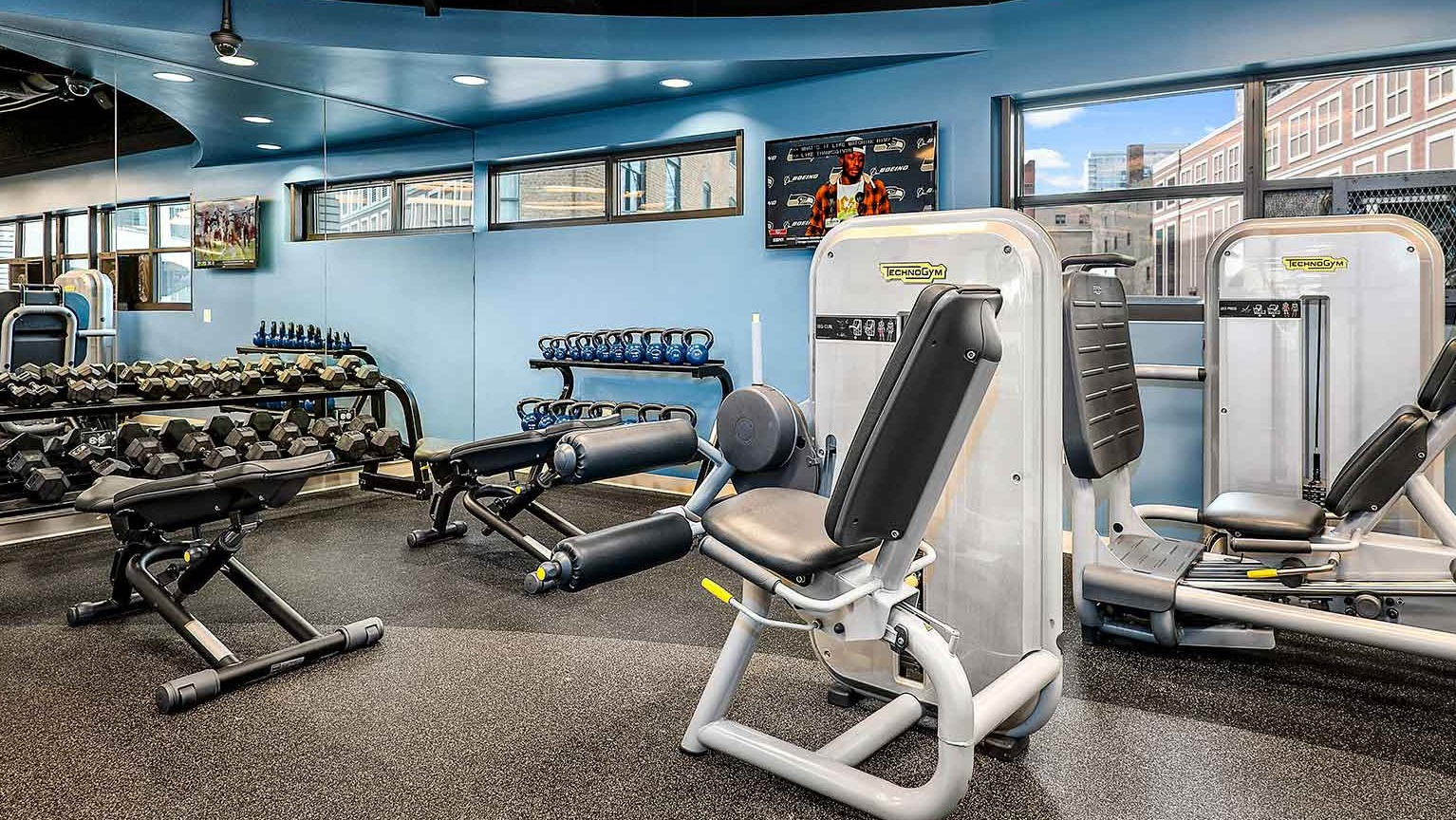 Comprehensive gym area featuring free weights, dumbbells, and various strength training machines, at Eleven Thirty apartments in Chicago