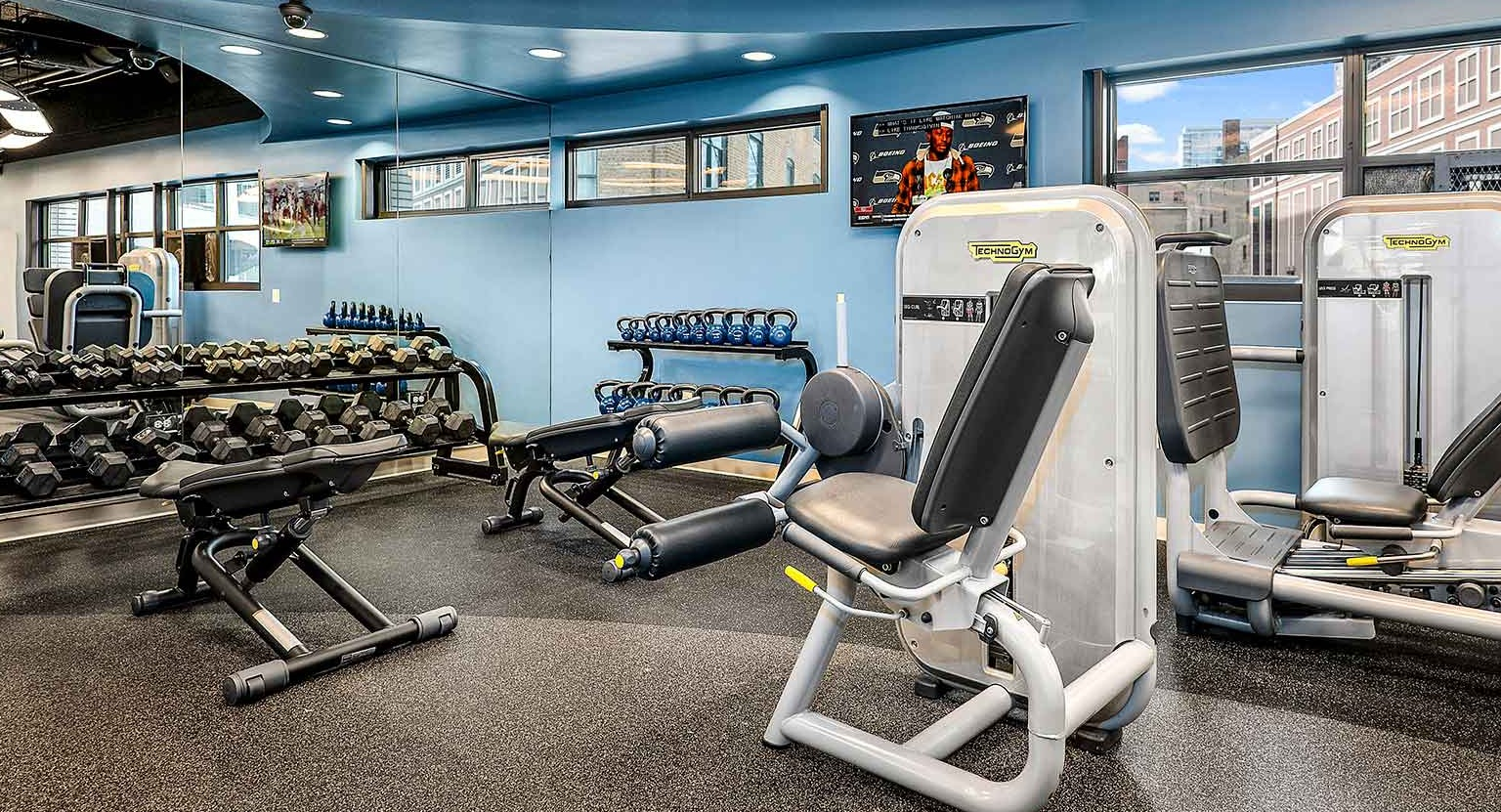 Comprehensive gym area featuring free weights, dumbbells, and various strength training machines, at Eleven Thirty apartments in Chicago