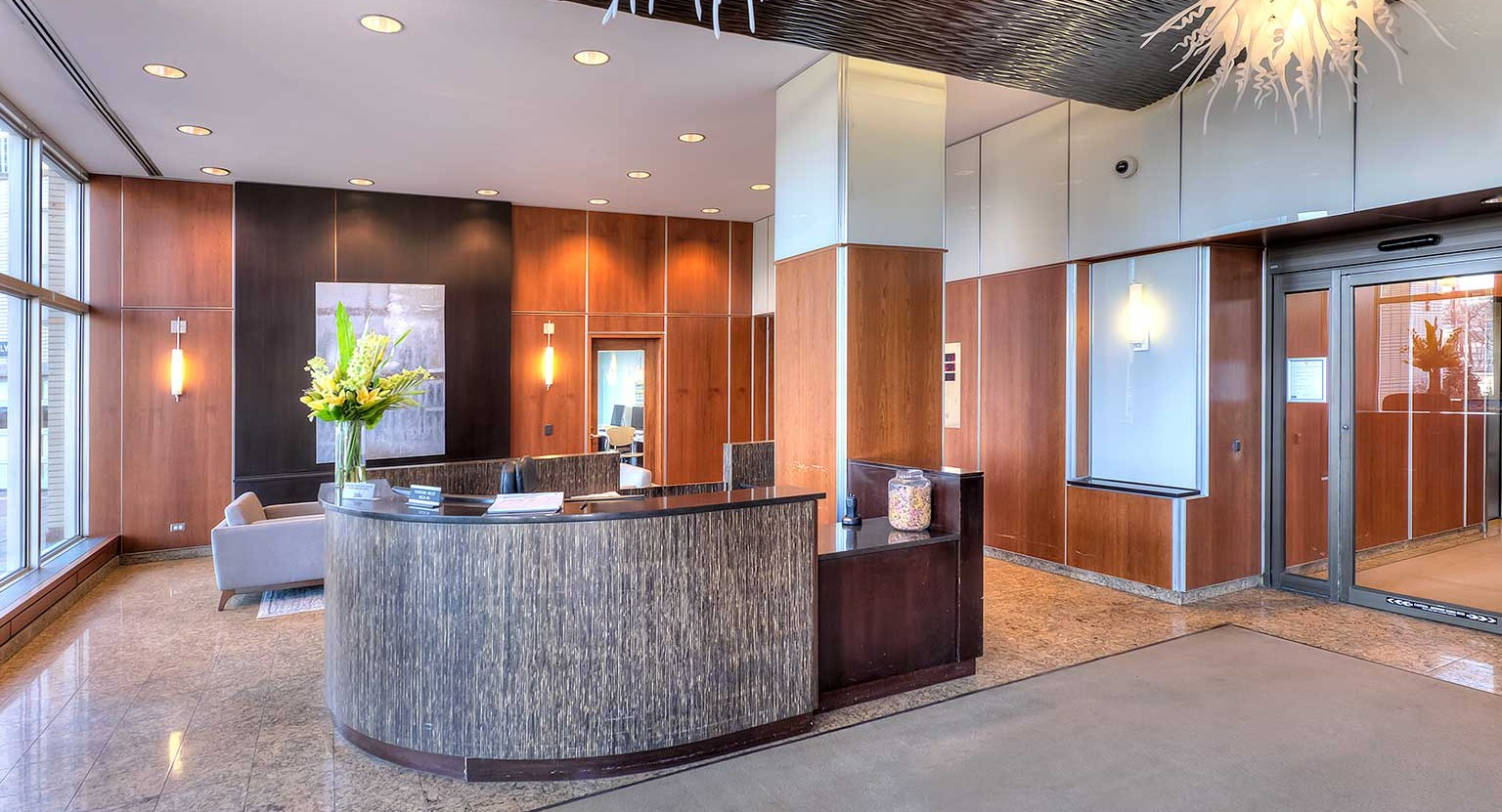 Elegant and spacious lobby with a welcoming concierge desk, modern decor, and comfortable seating at Eleven Thirty apartments in Chicago