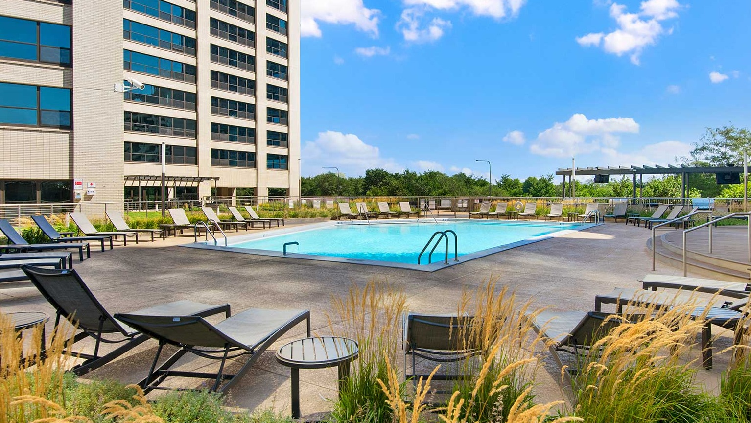 Expansive pool deck with numerous lounge chairs and stylish seating areas, ideal for sunbathing and relaxation at Eleven Thirty in Chicago