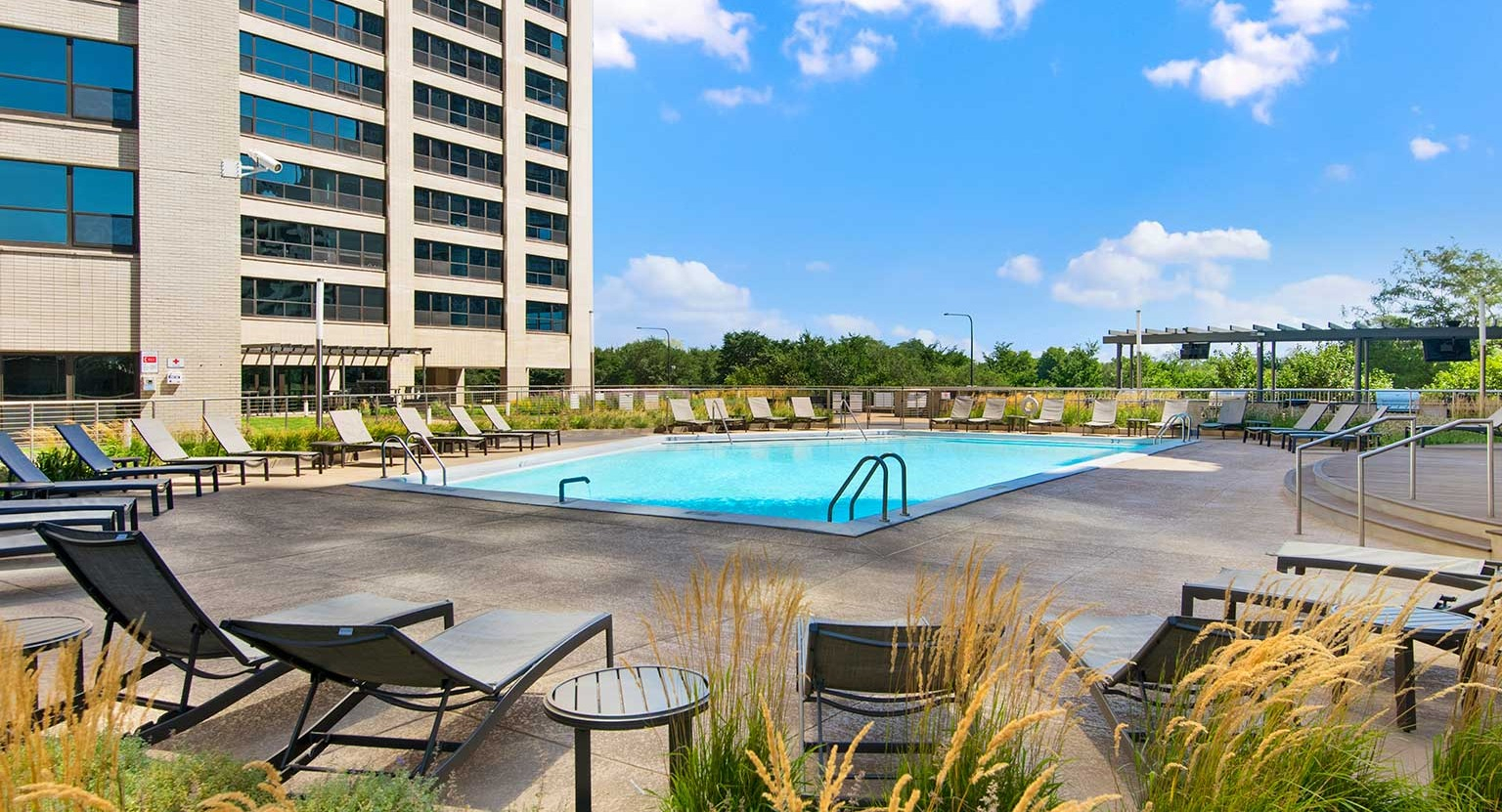 Expansive pool deck with numerous lounge chairs and stylish seating areas, ideal for sunbathing and relaxation at Eleven Thirty in Chicago
