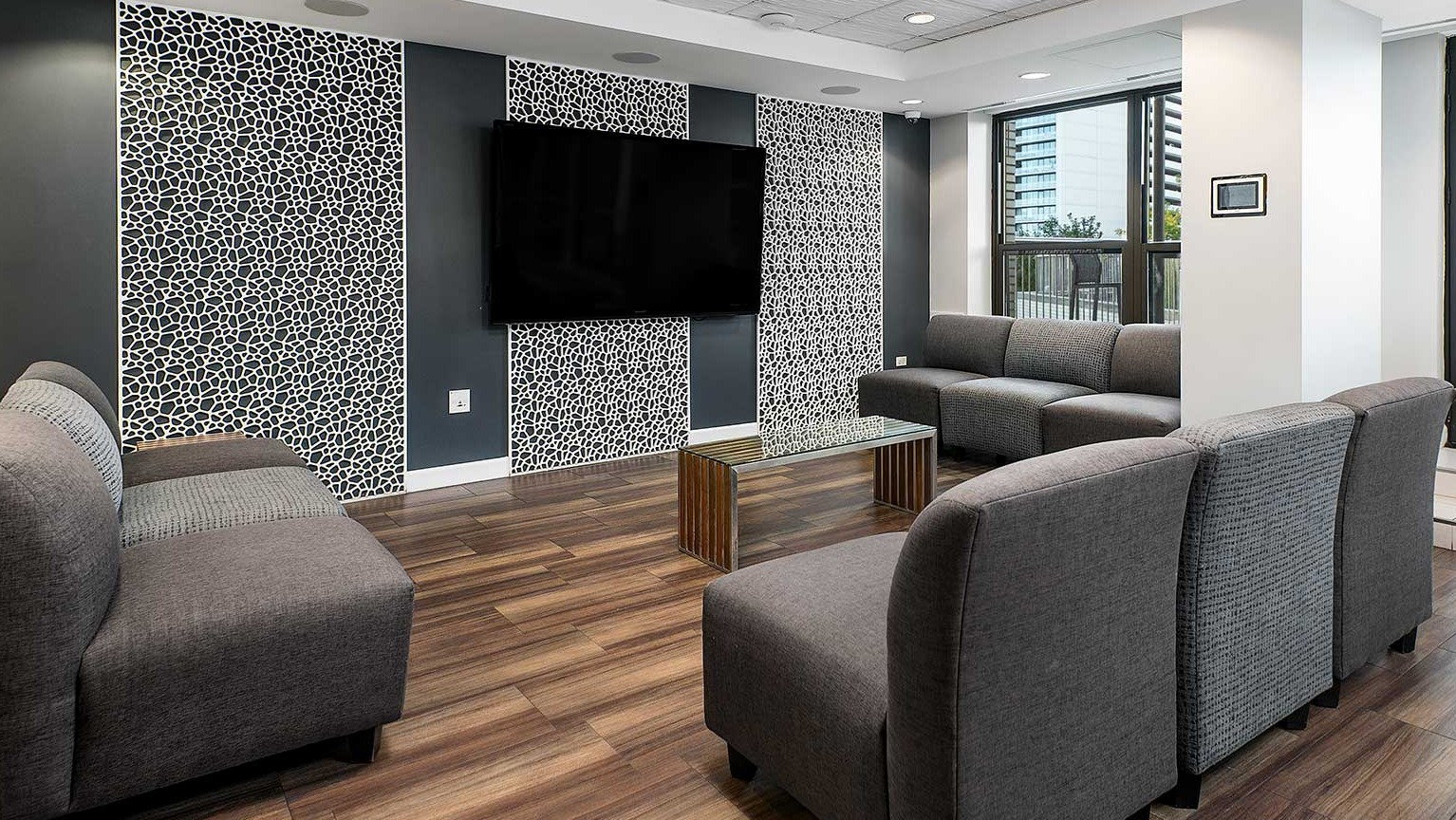 Comfortable resident lounge with plush seating, a large wall-mounted TV, and modern decor at Eleven Thirty apartments in Chicago