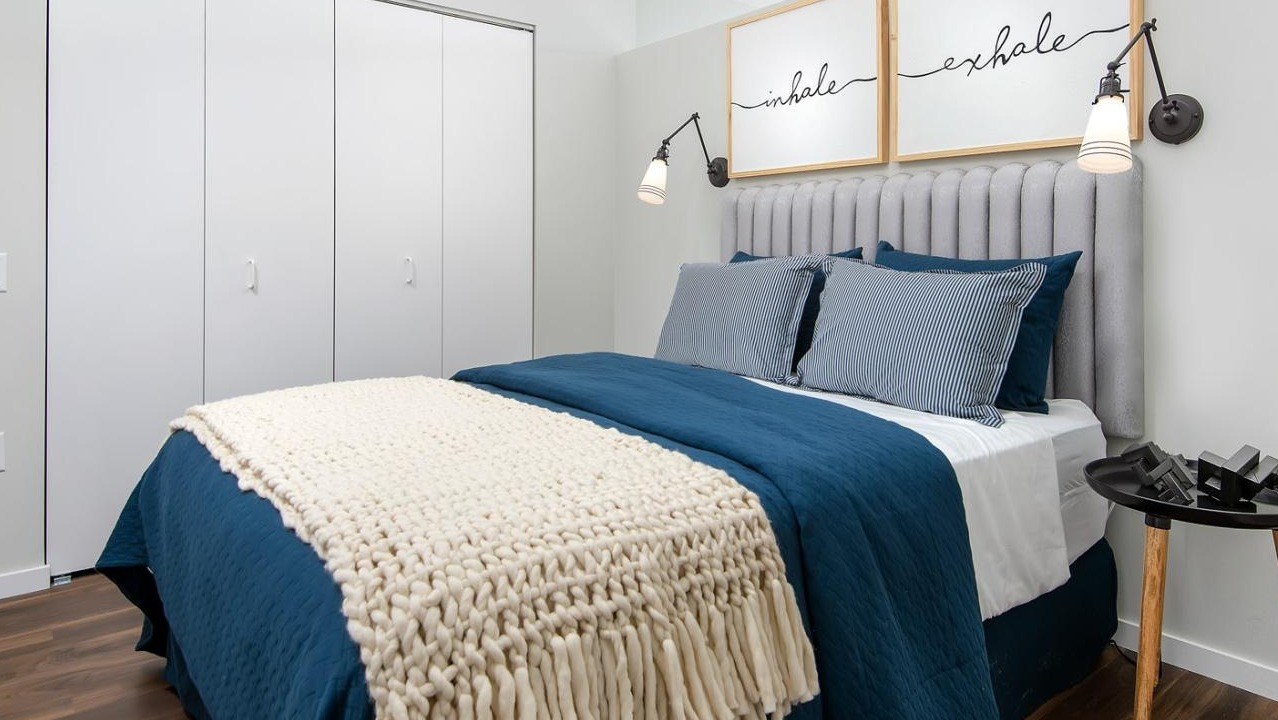 Cozy apartment bedroom with a comfortable bed, stylish blue bedding, and a large closet at Eleven40 apartments in Chicago