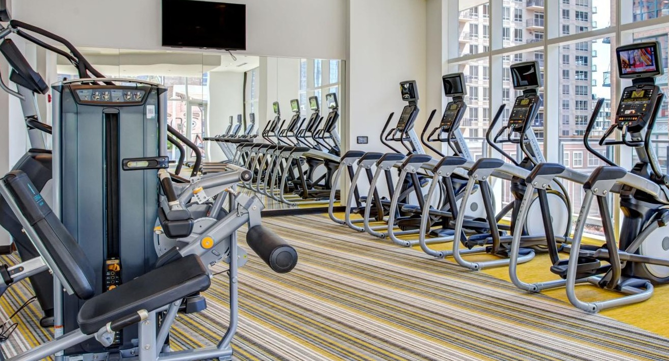 State-of-the-art fitness center with a variety of cardio machines, strength equipment, and large windows at Eleven40 apartments in Chicago
