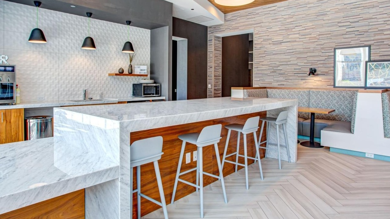 Modern resident lounge and bar area with stylish seating, a beverage station, and a communal dining space at Eleven40 in Chicago