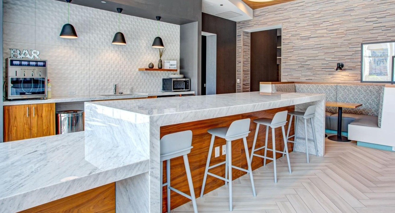 Modern resident lounge and bar area with stylish seating, a beverage station, and a communal dining space at Eleven40 in Chicago
