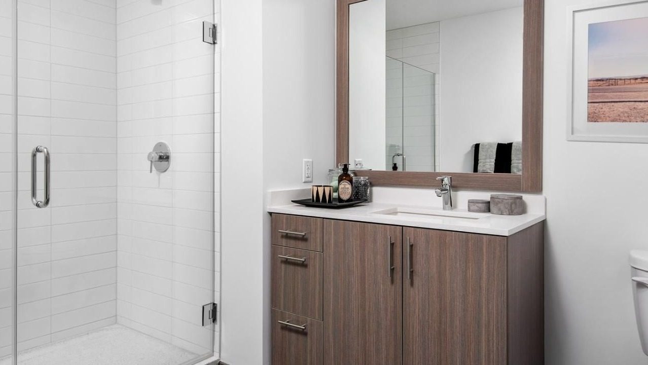 Modern apartment bathroom with a spacious walk-in shower, sleek vanity, and contemporary fixtures at Eleven40 apartments in Chicago