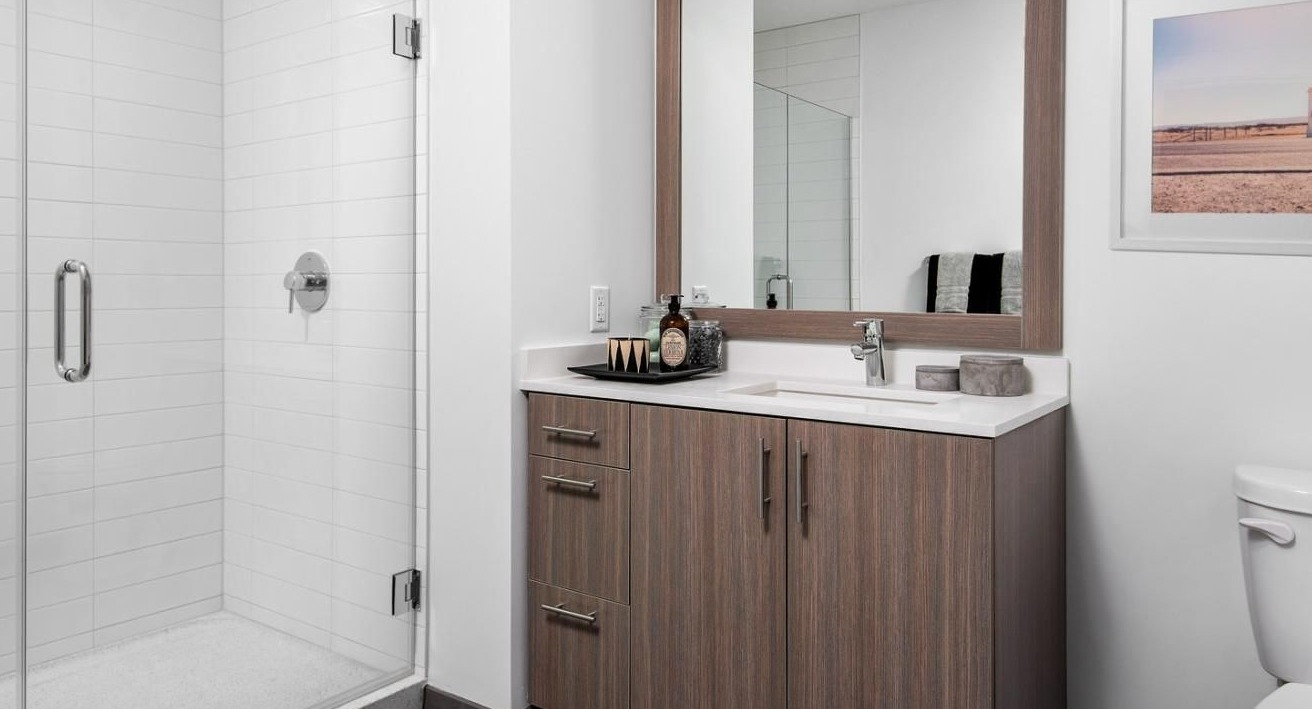 Modern apartment bathroom with a spacious walk-in shower, sleek vanity, and contemporary fixtures at Eleven40 apartments in Chicago