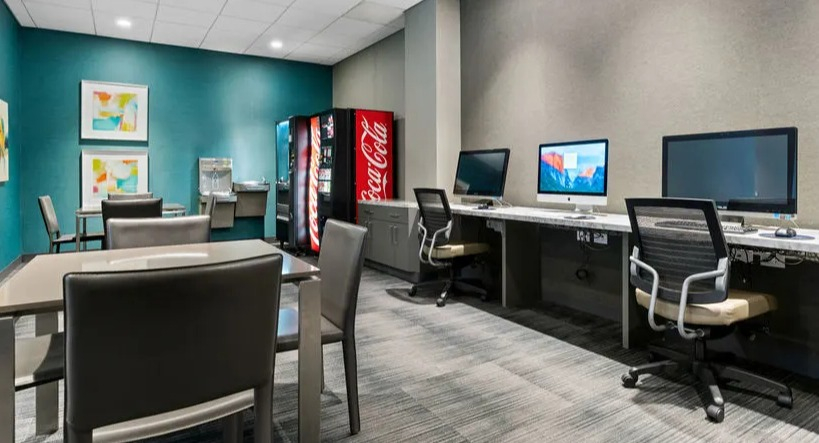 Modern business center and lounge with computer workstations and vending machines at Elm Street Plaza Chicago
