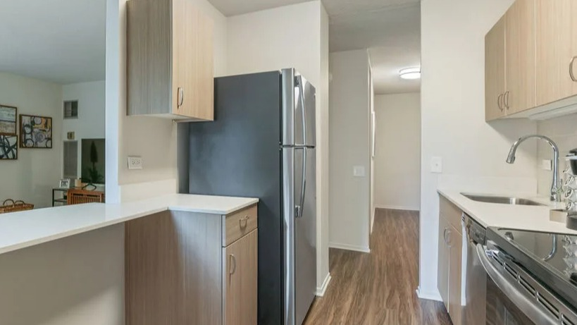 Kitchen with a convenient breakfast bar, stainless steel appliances, and plenty of cabinet storage at Elm Street Plaza Chicago