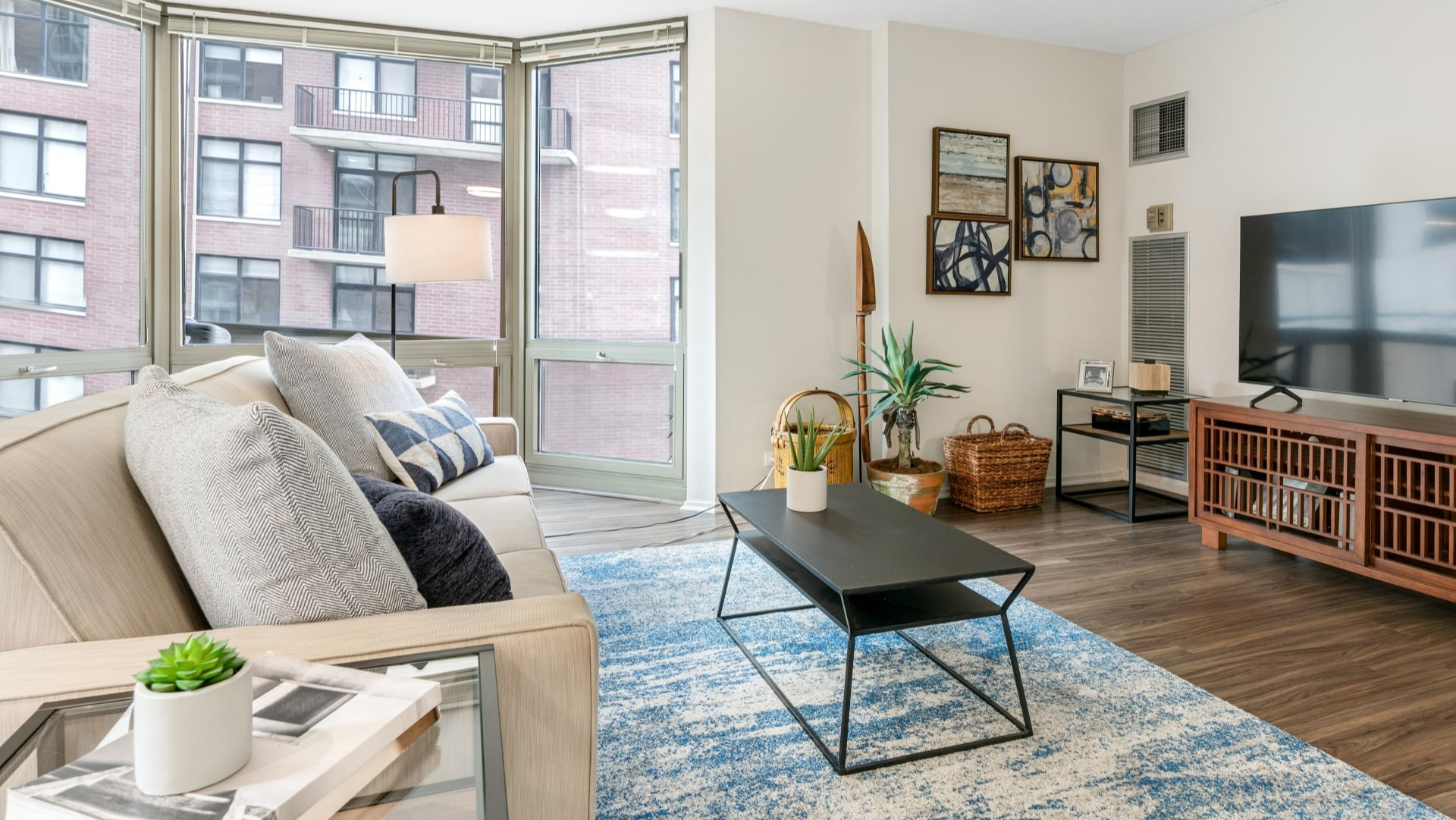 Living room designed for entertainment, featuring a television, stylish media console, and comfortable seating at Elm Street Plaza Chicago