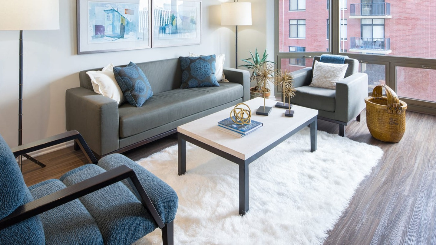 Modern living room with a comfortable sofa, accent chairs, and stylish decor at Elm Street Plaza Chicago