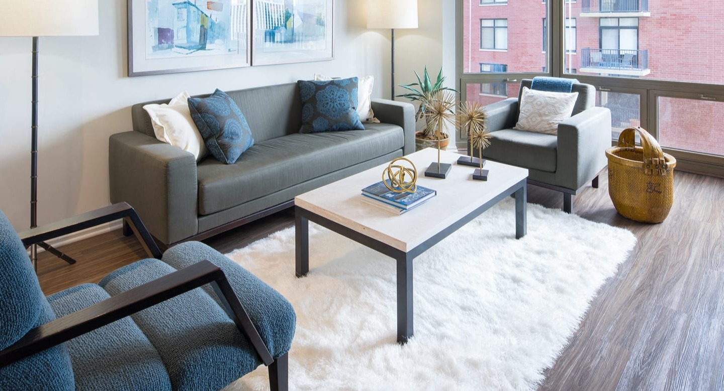 Modern living room with a comfortable sofa, accent chairs, and stylish decor at Elm Street Plaza Chicago