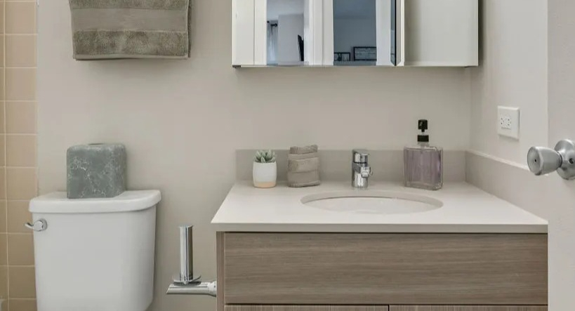 Modern bathroom with a light wood vanity, contemporary fixtures, and a shower/tub combo at Elm Street Plaza Chicago