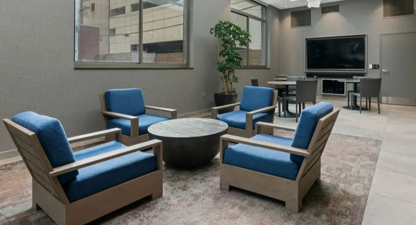 Resident lounge featuring a large screen TV, comfortable seating, and a bright, open atmosphere at Elm Street Plaza Chicago